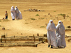 Algrie - Touggourt - Wilaya de Ouargla: femmes sur un chemin poussireux - nomme d'aprs une esclave origine berbro-portugaise  la beaut lgendaire - photographie par J.Kaman