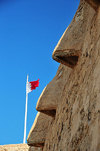 Arad, Muharraq Island, Bahrain: Arad Fort - these nose shaped openings in the upper part of the walls allowed marksmen to target enemy forces at close range - Bahraini flag - photo by M.Torres