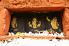 Bhutan - trio of Buddhist figures in the Mani wall of the Chendebji Chorten - photo by A.Ferrari