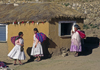 Isla del Sol, Lake Titicaca, Manco Kapac Province, La Paz Department, Bolivia: the local Aymara in their village of Yumani - mud house and women with their 'backpacks' - photo by C.Lovell