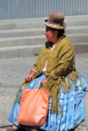 La Paz, Bolivia: Aymara woman with Chola dress, bowler hat and shawl rests in Plaza de los Hroes - photo by M.Torres