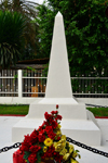 Douala,Cameroon: white obelisk - tomb with flowers downtown, by the gardens of the Chamber of Commerce - photo by M.Torres