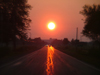 Port Colborne, Ontario, Canada / Kanada: sun on the asphalt - road at sunset - reflection - photo by R.Grove