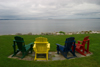 Canada 458 Close-up of 4 colourful Aderondack chairs and a view of the Atlantic Ocean from a garden located between Chester and Hubbards, Nova Scotia, Canada - photo by D.Smith