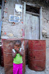Faj de gua, Brava island - Cape Verde / Cabo Verde: young girl and old fuel barrels - photo by E.Petitalot