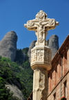 Montserrat, Catalonia: stone crucifix at Montserrat monastery, rock pinnacles in the background - photo by M.Torres
