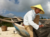 China - Hainan Island: old fisherman mending nets - Chinese hat (photo by G.Friedman)