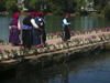 Lijiang, Yunnan Province, China: Dragon Park - flower vases and women with turbans by the water - photo by M.Samper