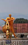 Goma, Nord-Kivu, Democratic Republic of the Congo: gilded statue of a cargo bike and its pusher, carrying the globe - roundabout center celebrating 50 years of Congolese independence - local trottinette called a chuckadoo, the symbol of Goma - photo by M.Torres