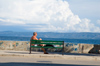 Croatia - Brac island - Bol: man on bench looking at the sea - photo by P.Gustafson
