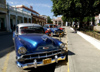 Cuba - Holgun - blue cars parked along curb - photo by G.Friedman