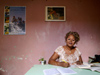Cuba - Holgun - secretary and red wall - an office worker studies at her desk - photo by G.Friedman