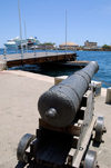 Curacao - Willemstad: Old Cannon in front of Koninin Emma Brug (pontoon bridge)with cruise ship moored off Otrobanda Mega Pier in the background - photo by S.Green