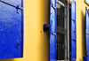 Puerto Plata, Dominican republic: yellow wall and windows with blue shutters - photo by M.Torres