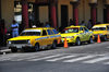 San Salvador, El Salvador, Central America: Parque Libertad - yellow taxis with black and white checker stripes along 'los portales' - photo by M.Torres