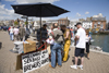 Weymouth, Dorset, England: people buying fresh line caught sea bass off local man in Brewers Quay - photo by I.Middleton