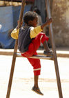 Eritrea - Keren, Anseba region: child sitting on an iron frame - photo by E.Petitalot