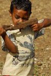 Eritrea - Mendefera, Southern region: aiming - a boy plays soldier with an old gun - photo by E.Petitalot