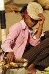Eritrea - Mendefera, Southern region: a girl selling roasted corn cobs at the market - photo by E.Petitalot