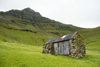 Trllanes, Kalsoy island, Noroyar, Faroes: rural cottage under a towering basalt peak - photo by A.Ferrari
