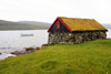 Srvagsvatn lake, Vgar island, Faroes: small stone house with sod roof on the lake shore - torvtak - photo by A.Ferrari