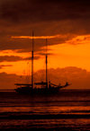 Yasawa Islands, Fiji: orange sunset with cloud cover over the Pacific Ocean  silhouette of La Violante, a 1920s double-masted schooner - photo by C.Lovell