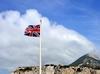 Gibraltar: Union Jack in the wind and southern view of the Rock, Europa Point - orographic clouds - hoto by M.Torres