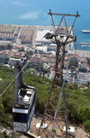 Gibraltar: a cable car gondola near the summit station, seen against Gibraltar harbour - photo by M.Torres