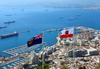Gibraltar: flag of Gibraltar (right) and the Government Ensign (left) - seen against the bay of Algeciras and the town - photo by M.Torres