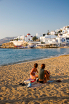 Greek islands - Mykonos (Hora) / Mikonos / JMK: town beach - two girls sitting - photo by D.Simth