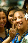 Hawai'i - Oahu island - Waikiki beach: teenage girls dressed in Hula costume with one girl showing peace symbol and wearing a flower in her hair - photo by D.Smith
