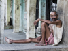 Varanasi, Uttar Pradesh, India: thin man sits outside a house - photo by J.Hernndez