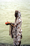 India - Uttaranchal - Rishikesh: a pilgrim prepares to place an offering on the Ganges / Ganga river - photo by W.Allgwer