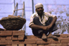 Amritsar (Punjab): construction worker sitting on a brick wall - photo by W.Allgwer