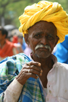 Bundi, Rajasthan, India: old man wearing a yellow turban and smoking - photo by M.Wright