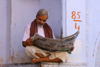 Pushkar, Rajasthan, India: man reading a newspaper - photo by M.Wright