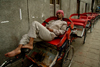 New Delhi, India: cycle rikshaw driver sleeping on his vehicle - siesta - photo by G.Koelman