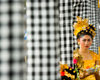 Padangbai, Bali, Indonesia: portrait of young Balinese woman wearing traditional costumes next to checked patterned cloth on columns - photo by D.Smith
