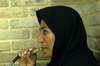 Iran - Shiraz, Fars province: woman with chador smoking a water pipe - narghile - photo by W.Allgower