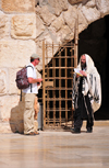 Jerusalem,  Israel: secular man with a backpack and an Orthodox Jew covered in a Kosher wool Tallit prayer shawl - Western Wall plaza - photo by M.Torres