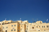 Jerusalem, Israel: stone buildings - view from the Western Wall plaza, Yeshivat Netiv Aryeh - Zionist Orthodox yeshiva - flags and antennas - Jewish quarter - Blue sky background as copy space for your text - photo by M.Torres