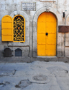 Jerusalem, Israel: ancient faade of a former burghul factory, with yellow door and window on Armenian Orthodox Patriarchate Road - Bulghourji Armenian Restaurant and Lounge - wrought Iron Latticework - Armenian quarter - photo by M.Torres