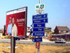 Kosovo - Bank billboard and direction boards by the road - photo by J.Kaman