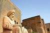 Erbil / Hewler / Arbil / Irbil, Kurdistan, Iraq: statue of the historian Ibn Al-Mustawfi aka Mubarak Ben Ahmed Sharaf-Aldin and red brick buildings near the entrance to Erbil Citadel - Qelay Hewlr - UNESCO world heritage site - photo by M.Torres