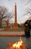 Bishkek, Kyrgyzstan: fire and love - couple at the Red Guards Memorial - Oak Park - red granite obelisk - grave of the Bolshevik casualties of the 1918 Belovodsk uprising - eternal flame - photo by M.Torres