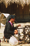 Laos: in a typical Laos village a woman is handspinning wool - spinning wheel - worsted - photo by E.Petitalot