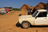 Tsimafana, Belo sur Tsiribihina district, Menabe Region, Toliara Province, Madagascar: huts and battered Peugeot 504 pickup -  European Car of the Year in 1969 - photo by M.Torres