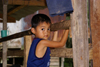 Skandis, Lubok Antu District, Sarawak, Borneo, Malaysia: young Iban boy, inside the longhouse - photo by A.Ferrari