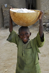 Djenn, Mopti Region, Mali: boy carrying a flour container on his head - photo by J.Pemberton