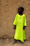 Timbuktu / Tombouctou, Mali: young boy in bright gelabaya agains a mud wall - photo by J.Pemberton
